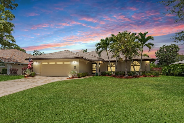 1333 SW Cedar Cv, Port Saint Lucie, FL 34986 - view of front of home featuring a tile roof, concrete driveway, stucco siding, a garage, and a lawn