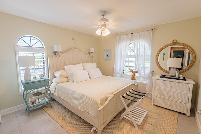 bedroom with baseboards, a ceiling fan, and light tile patterned floors