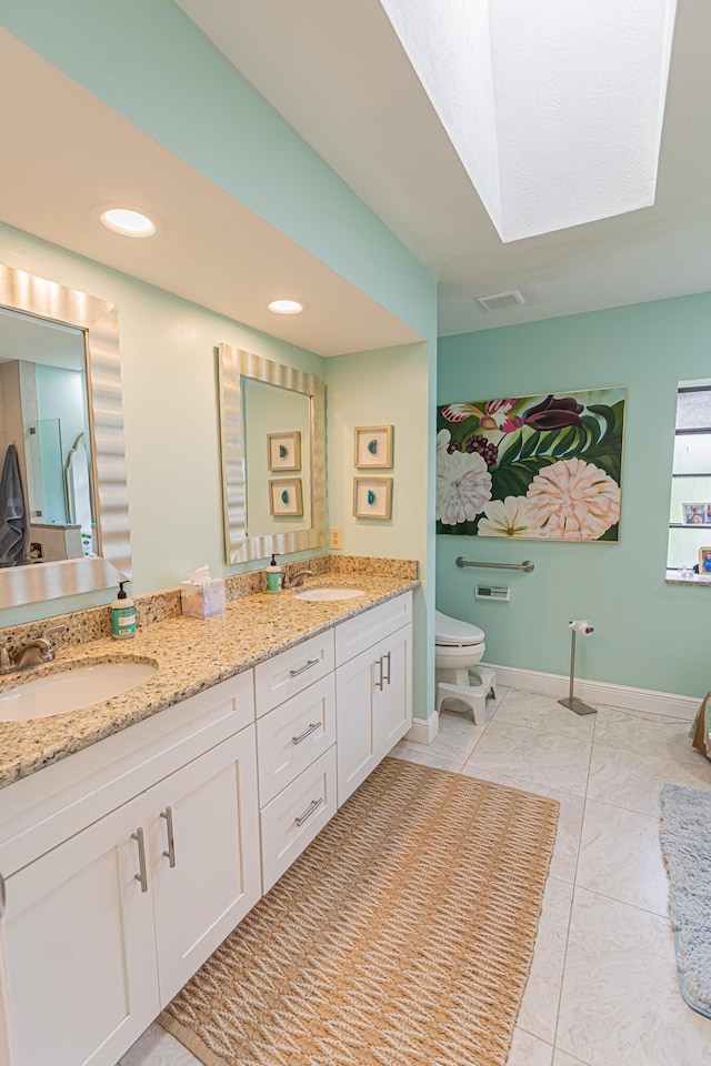 bathroom with double vanity, a sink, visible vents, and toilet