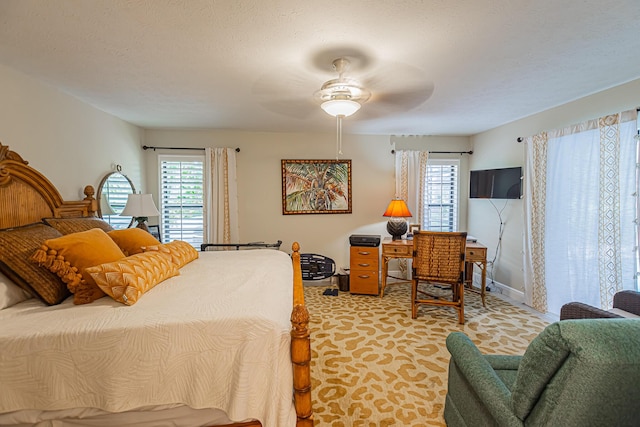 bedroom with baseboards, light carpet, and a ceiling fan