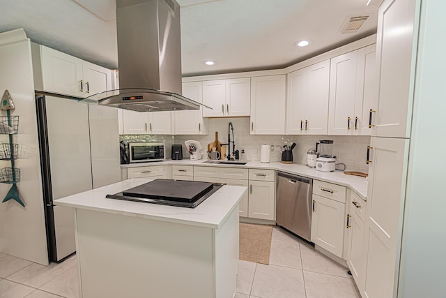 kitchen with island range hood, white cabinets, a sink, appliances with stainless steel finishes, and light tile patterned floors