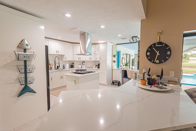 kitchen featuring a sink, recessed lighting, white cabinetry, and island range hood