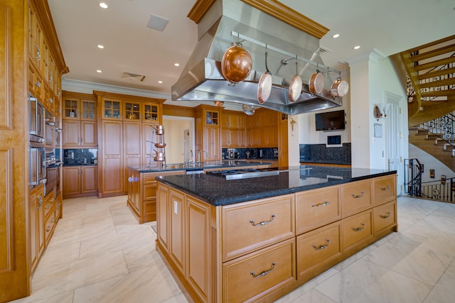 kitchen featuring crown molding, stainless steel gas stovetop, tasteful backsplash, a kitchen island, and visible vents