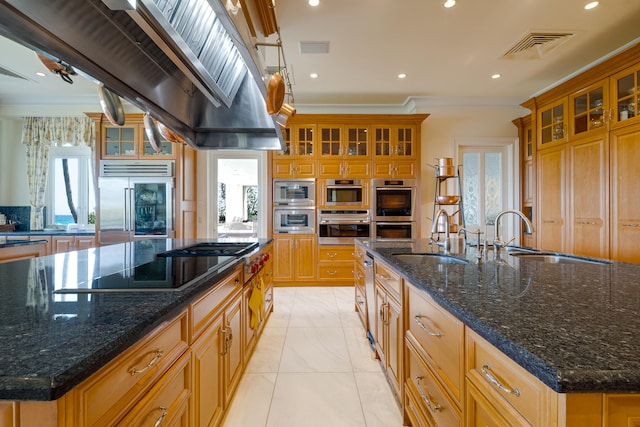 kitchen featuring recessed lighting, a sink, built in appliances, and a spacious island