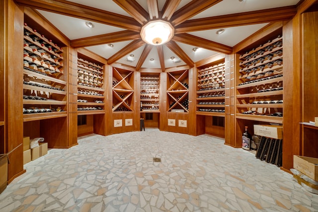 wine room with built in features, stone floors, and beamed ceiling