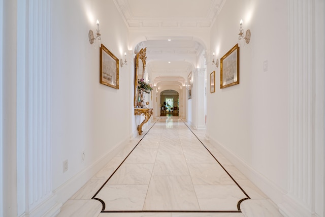 hall with crown molding, arched walkways, and marble finish floor