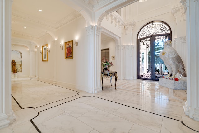 foyer with decorative columns, ornamental molding, french doors, and marble finish floor