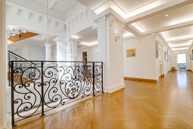 corridor with baseboards, ornamental molding, and decorative columns