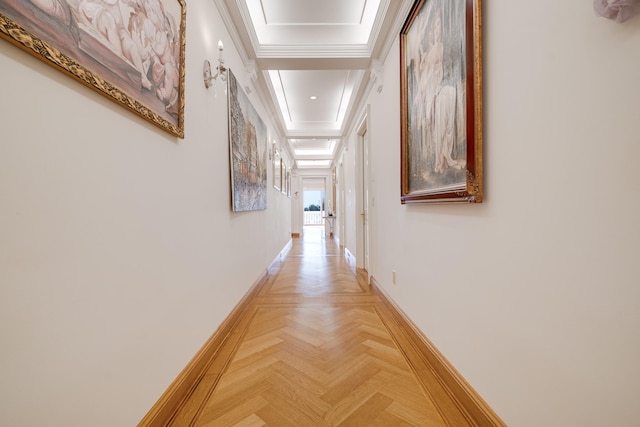 hallway featuring baseboards, ornamental molding, and attic access