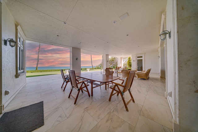 interior space with outdoor dining area and a water view