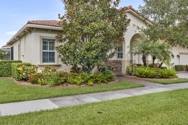 10245 SW Reggiani Rd, Port Saint Lucie, FL 34986 - mediterranean / spanish home with stucco siding, a tiled roof, and a front yard
