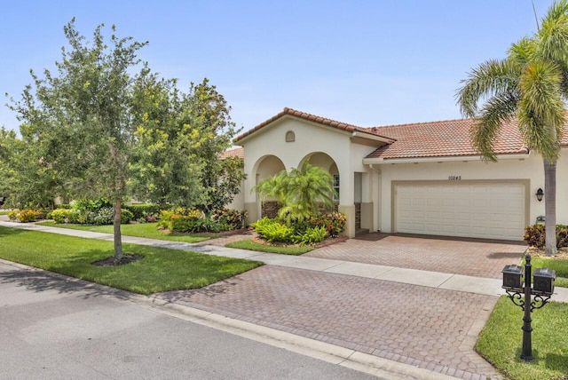 10245 SW Reggiani Rd, Port Saint Lucie, FL 34986 - mediterranean / spanish home featuring an attached garage, decorative driveway, stucco siding, and a front yard