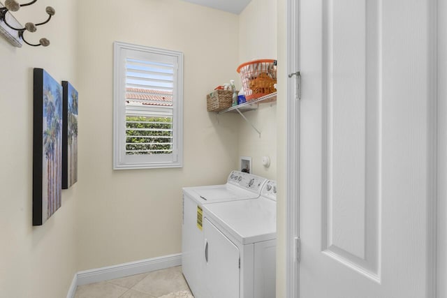 10245 SW Reggiani Rd, Port Saint Lucie, FL 34986 - laundry area with washing machine and clothes dryer, light tile patterned floors, laundry area, and baseboards