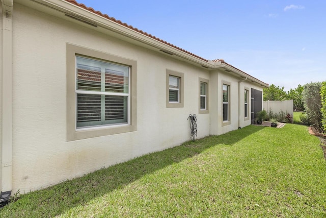 10245 SW Reggiani Rd, Port Saint Lucie, FL 34986 - view of side of property featuring stucco siding, a yard, and a tile roof