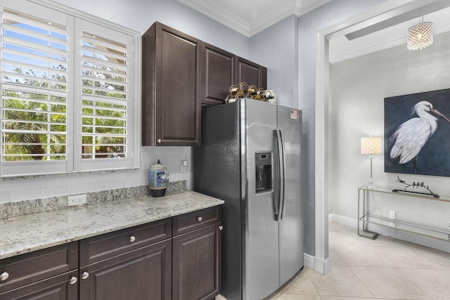 10245 SW Reggiani Rd, Port Saint Lucie, FL 34986 - kitchen featuring dark brown cabinets, stainless steel fridge, baseboards, light tile patterned floors, and ornamental molding