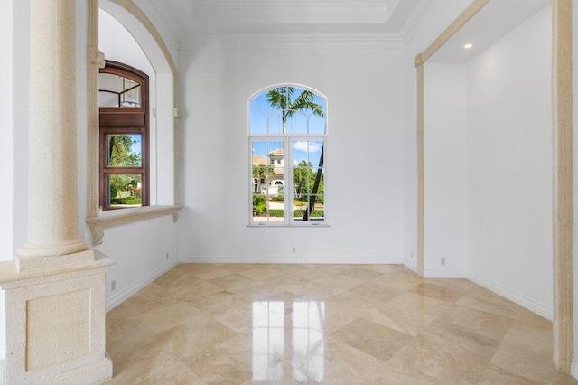 interior space with crown molding, ornate columns, and baseboards
