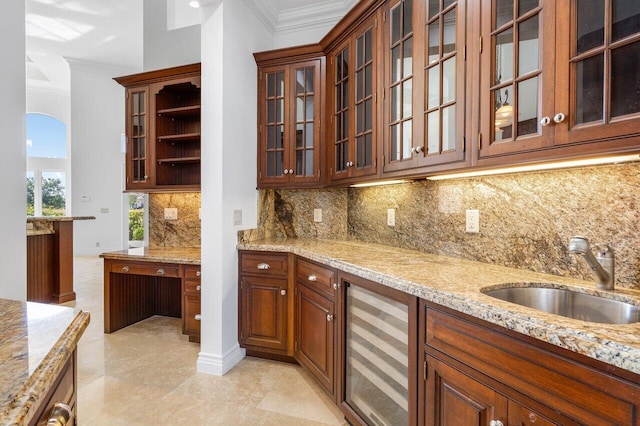 kitchen featuring ornamental molding, light stone countertops, beverage cooler, tasteful backsplash, and a sink