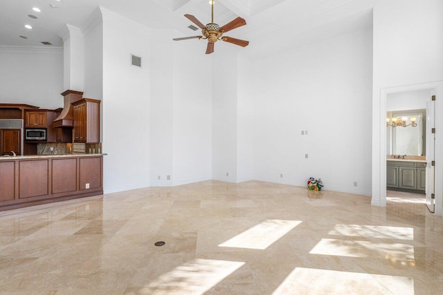 unfurnished living room with visible vents, ornamental molding, baseboards, a high ceiling, and ceiling fan with notable chandelier