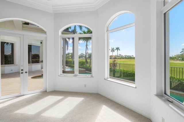 unfurnished sunroom with baseboards, ornamental molding, carpet, and french doors