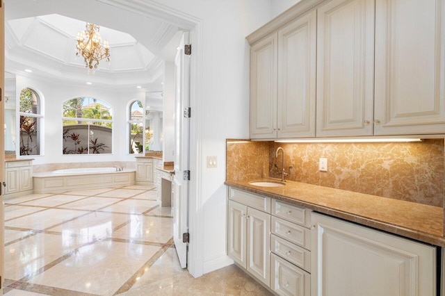 bathroom with a garden tub, ornamental molding, marble finish floor, tasteful backsplash, and a notable chandelier