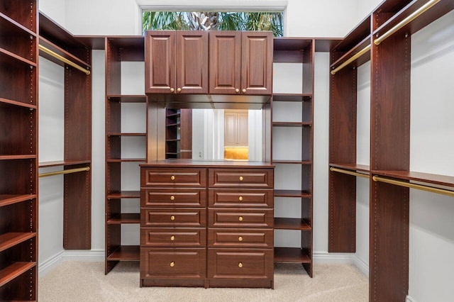 walk in closet featuring light colored carpet