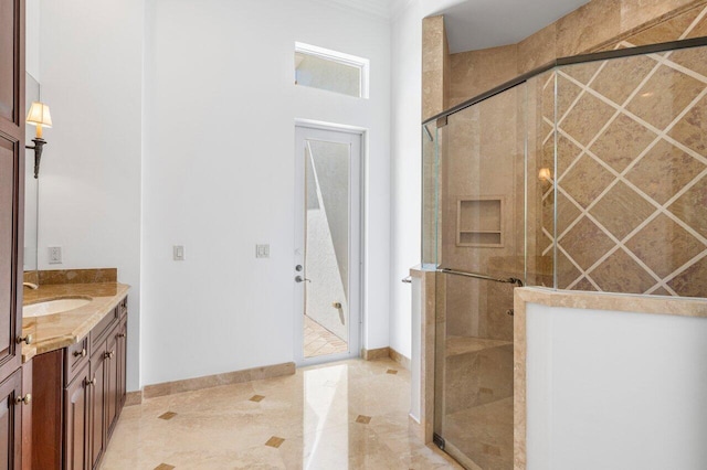 bathroom featuring baseboards, a shower stall, ornamental molding, and vanity