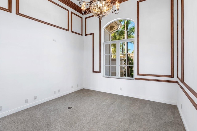 unfurnished room featuring an inviting chandelier, carpet flooring, and baseboards