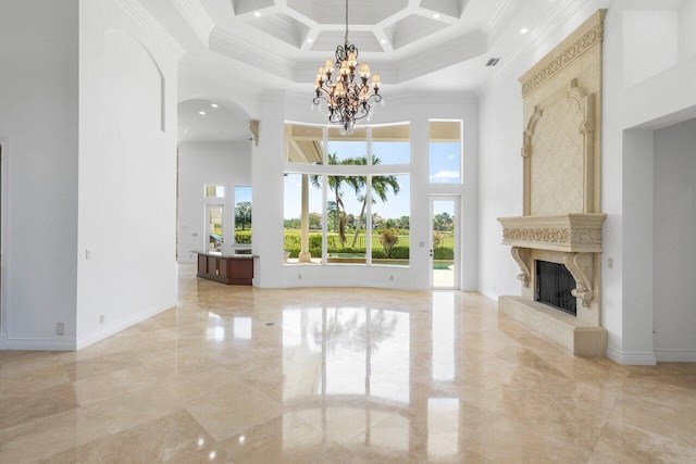 unfurnished living room with a high end fireplace, a high ceiling, ornamental molding, and a notable chandelier
