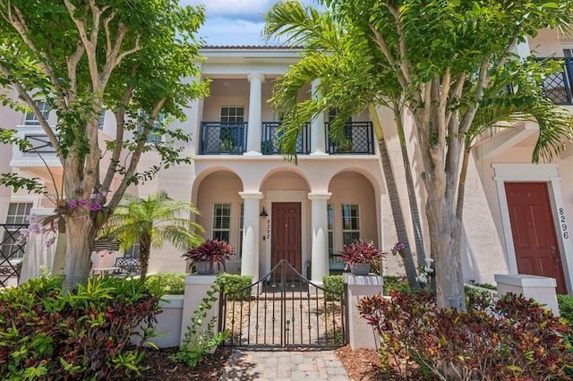 8292 NW 9th Ave, Boca Raton, FL 33487 - view of exterior entry with a balcony, stucco siding, fence, and a gate