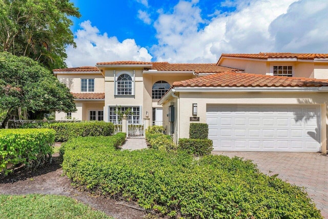 5607 NW 24th Ter, Boca Raton, FL 33496 - mediterranean / spanish home featuring an attached garage, driveway, a tile roof, and stucco siding