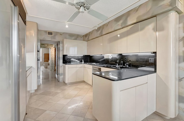 7578 Regency Lake Dr Unit 702, Boca Raton, FL 33433 - kitchen featuring a sink, a peninsula, tasteful backsplash, visible vents, and dark countertops