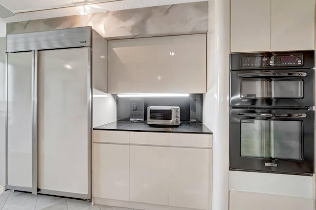7578 Regency Lake Dr Unit 702, Boca Raton, FL 33433 - kitchen featuring a toaster, white cabinetry, dobule oven black, paneled fridge, and dark countertops