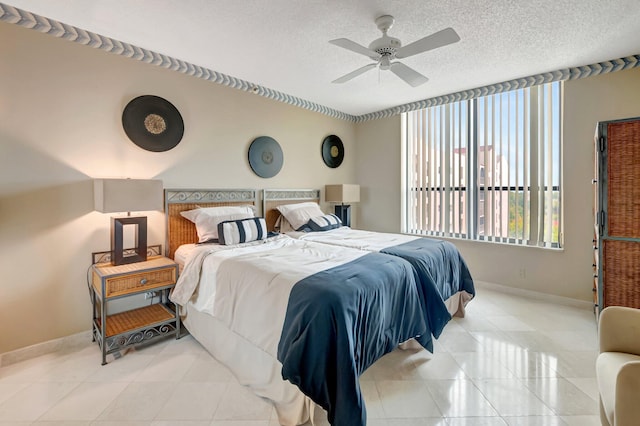 7578 Regency Lake Dr Unit 702, Boca Raton, FL 33433 - bedroom with baseboards, tile patterned flooring, ceiling fan, and a textured ceiling