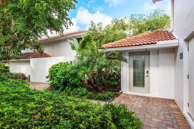 4107 Kittiwake Ct Kittiwake, Unit Kittiwake, Boynton Beach, FL 33436 - view of exterior entry featuring a tiled roof and stucco siding