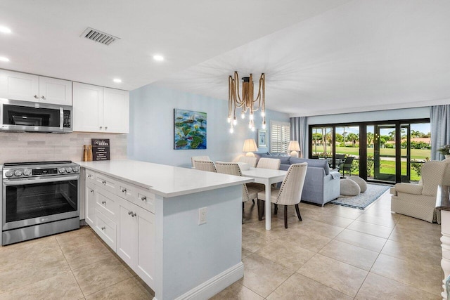 4107 Kittiwake Ct Kittiwake, Unit Kittiwake, Boynton Beach, FL 33436 - kitchen featuring appliances with stainless steel finishes, open floor plan, a peninsula, tasteful backsplash, and light countertops