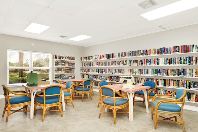 exercise room with plenty of natural light, wood finished floors, and a paneled ceiling