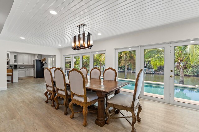 1256 Holly Cove Dr, Jupiter, FL 33458 - dining space featuring recessed lighting, an inviting chandelier, french doors, and light wood-type flooring