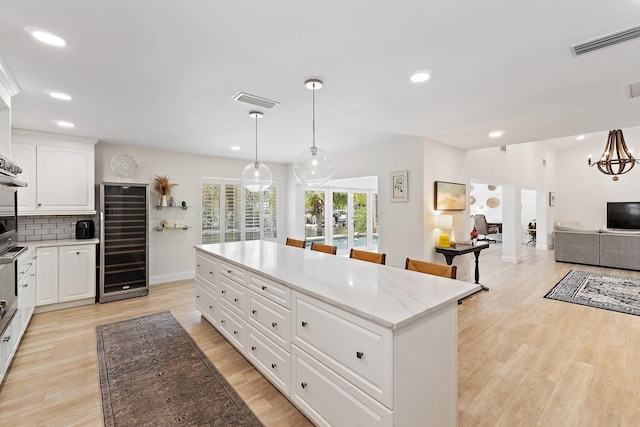 1256 Holly Cove Dr, Jupiter, FL 33458 - kitchen featuring beverage cooler, recessed lighting, baseboards, a kitchen island, and visible vents