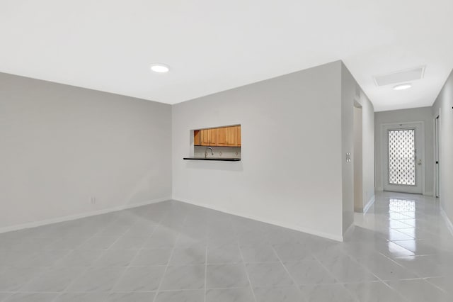 1341 NW 19 Th Ter Unit A, Delray Beach, FL 33445 - empty room featuring light tile patterned floors, baseboards, attic access, and a sink