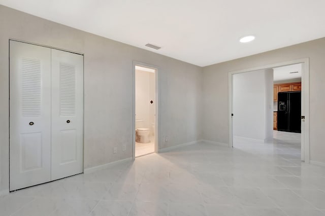 1341 NW 19 Th Ter Unit A, Delray Beach, FL 33445 - unfurnished bedroom with black fridge with ice dispenser, baseboards, a closet, ensuite bath, and recessed lighting