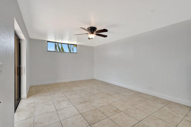 unfurnished room featuring light tile patterned flooring, ceiling fan, and baseboards