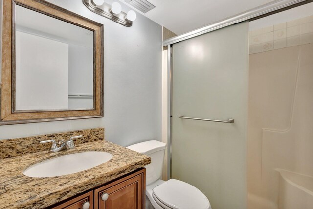 bathroom with visible vents, vanity, toilet, and a shower stall