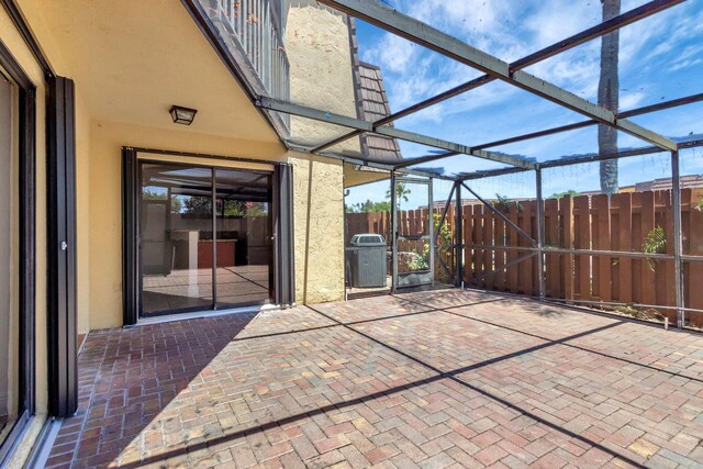 view of patio / terrace with fence and glass enclosure