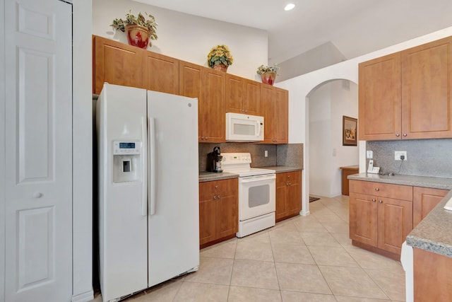 12249 Blair Ave, Boynton Beach, FL 33437 - kitchen featuring white appliances, arched walkways, recessed lighting, light tile patterned floors, and backsplash