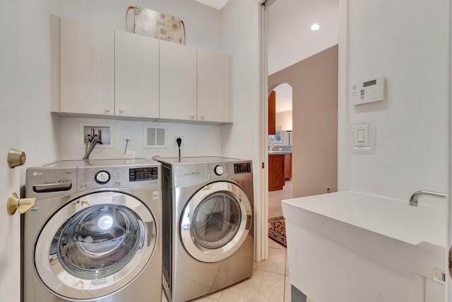 12249 Blair Ave, Boynton Beach, FL 33437 - clothes washing area featuring visible vents, arched walkways, cabinet space, light tile patterned floors, and washer and clothes dryer