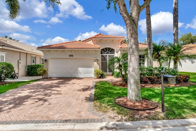 12249 Blair Ave, Boynton Beach, FL 33437 - mediterranean / spanish-style home with a garage, a tiled roof, decorative driveway, and stucco siding