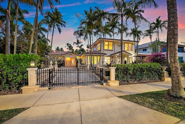 view of front of property with a fenced front yard, stucco siding, and a gate