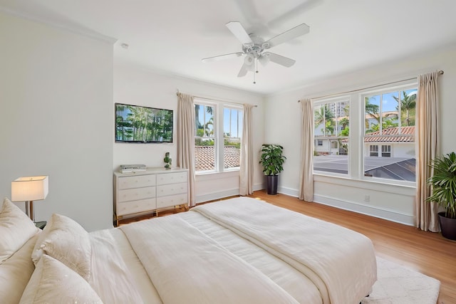 bedroom with baseboards, light wood-type flooring, and a ceiling fan