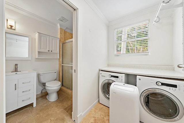 clothes washing area featuring baseboards, ornamental molding, a sink, washing machine and clothes dryer, and laundry area