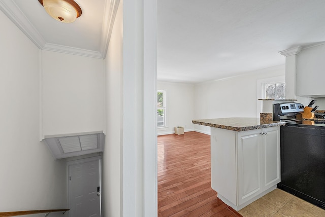 kitchen featuring electric stove, ornamental molding, a peninsula, white cabinets, and dark countertops